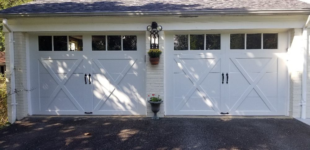 A white garage door with a lantern on the side of it
