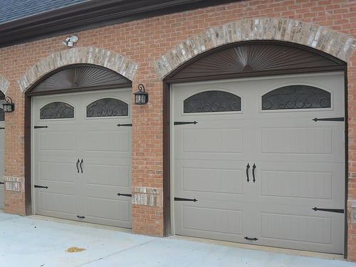 A row of garage doors on a brick building.
