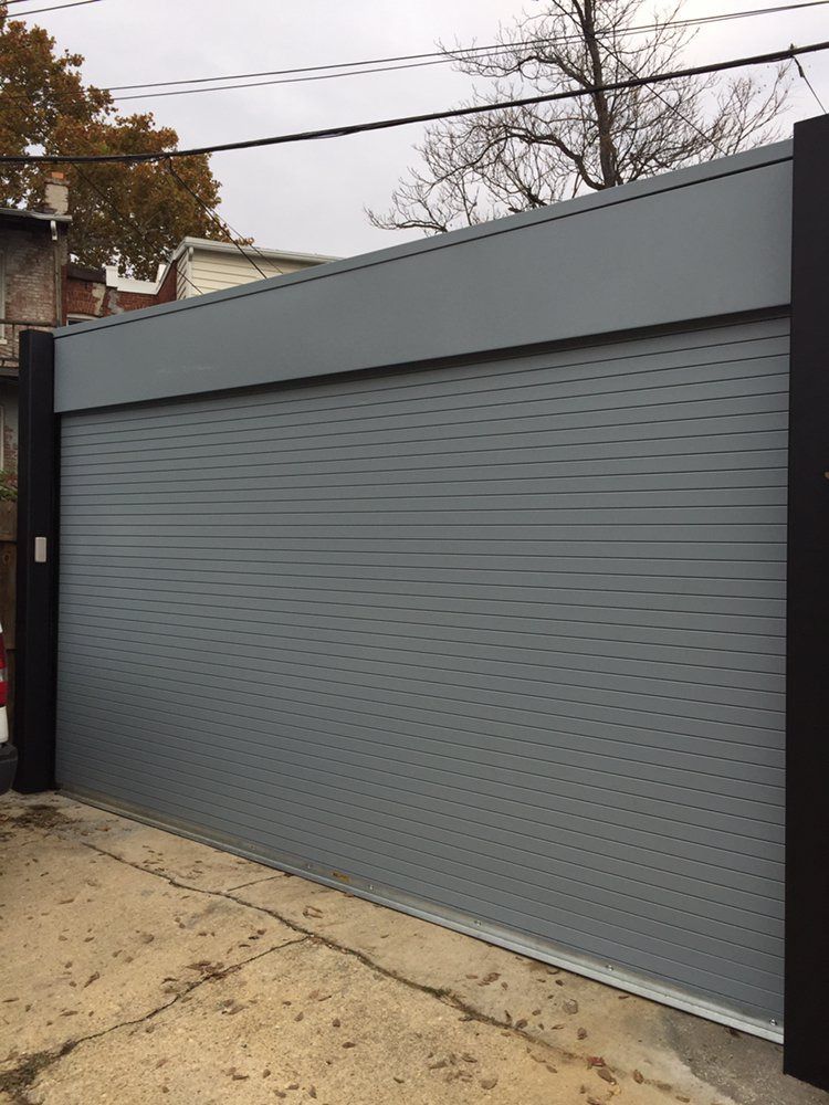 A large gray garage door is sitting on the side of the road.