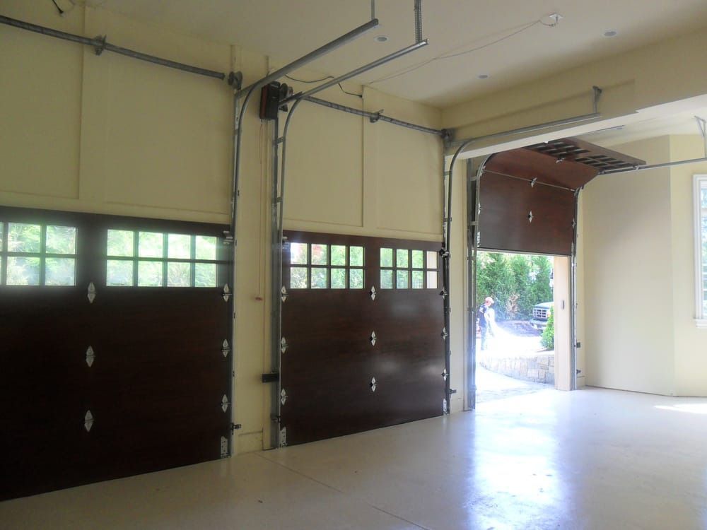 An empty garage with two garage doors open