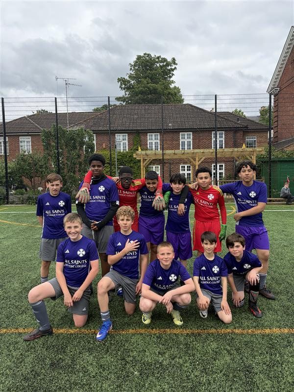 Youth soccer team posing on a grassy field, with houses in the background.