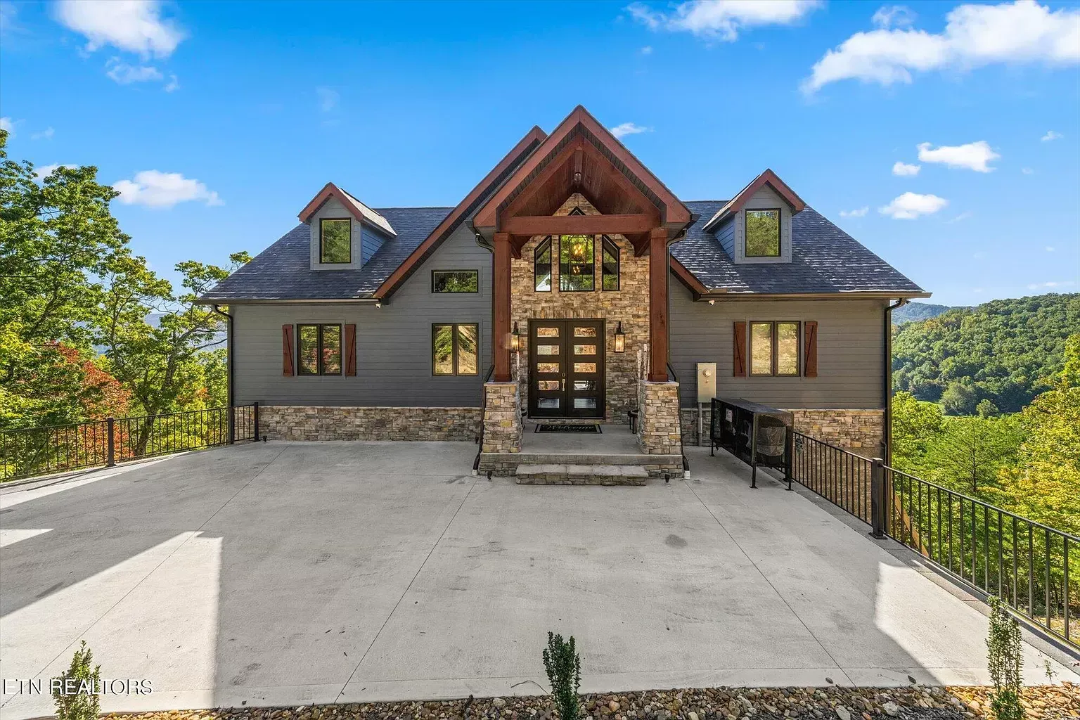 A large house with a lot of windows is sitting on top of a hill.