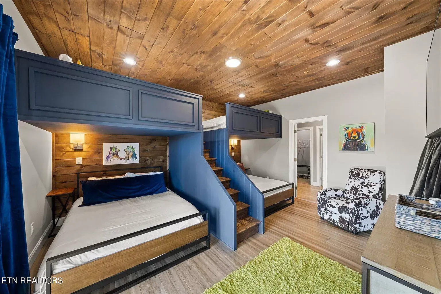 A bedroom with two bunk beds and a chair.