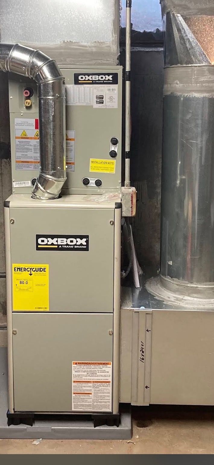 Large gray HVAC furnace beside a wrapped duct in a utility room