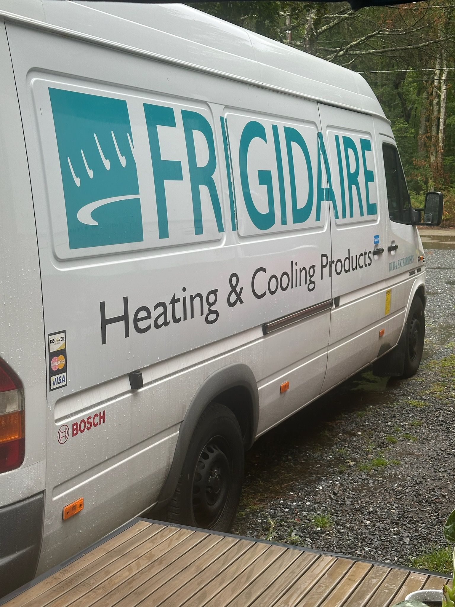 Stacked old air conditioners and window units in a cluttered storage area