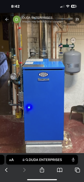 Worker bending over outdoor HVAC unit, handling black cables near a white air conditioner