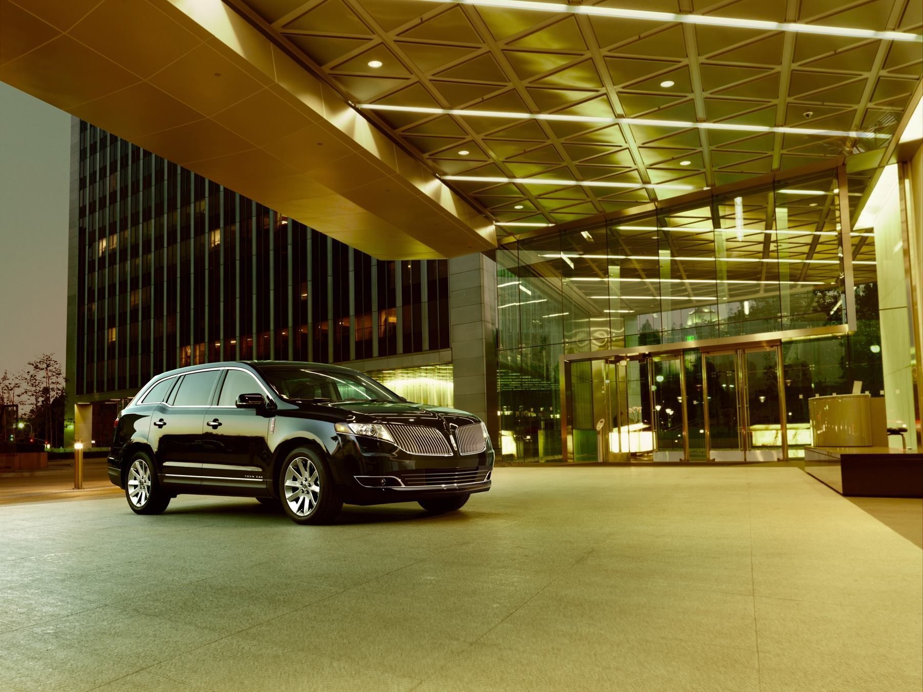 A black suv is parked in front of a building