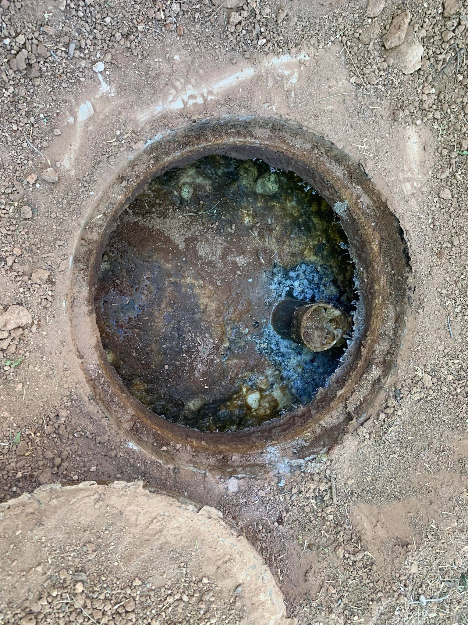A manhole cover with water coming out of it.
