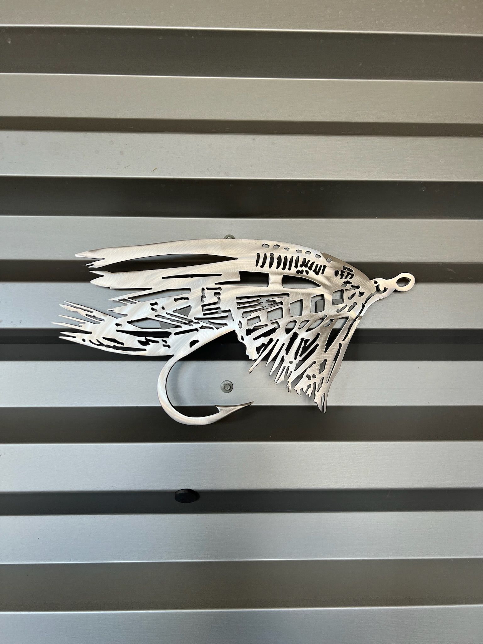 A drawing of a fly with a hook on a wall