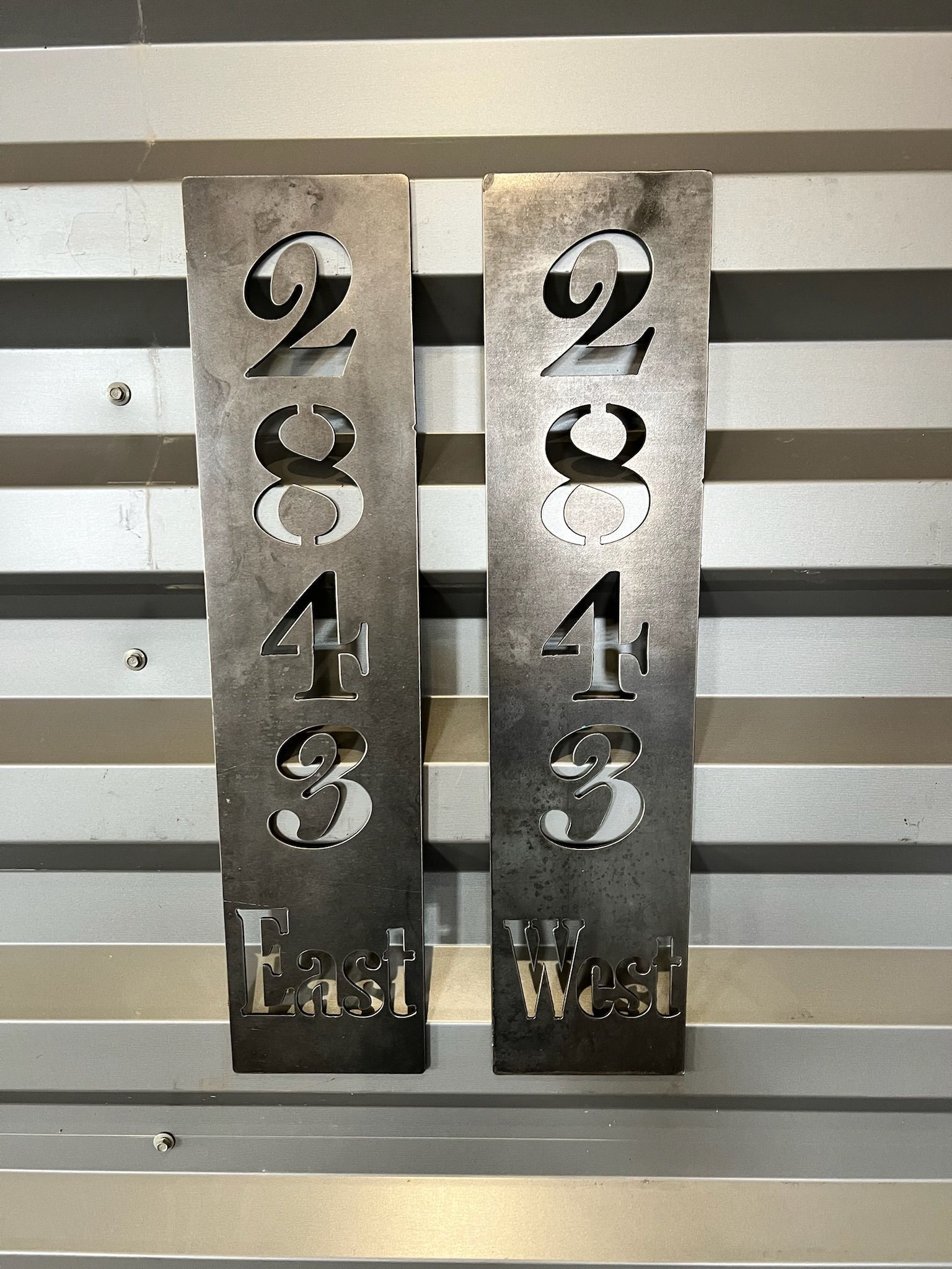 Two metal signs with numbers on them are sitting on a table.