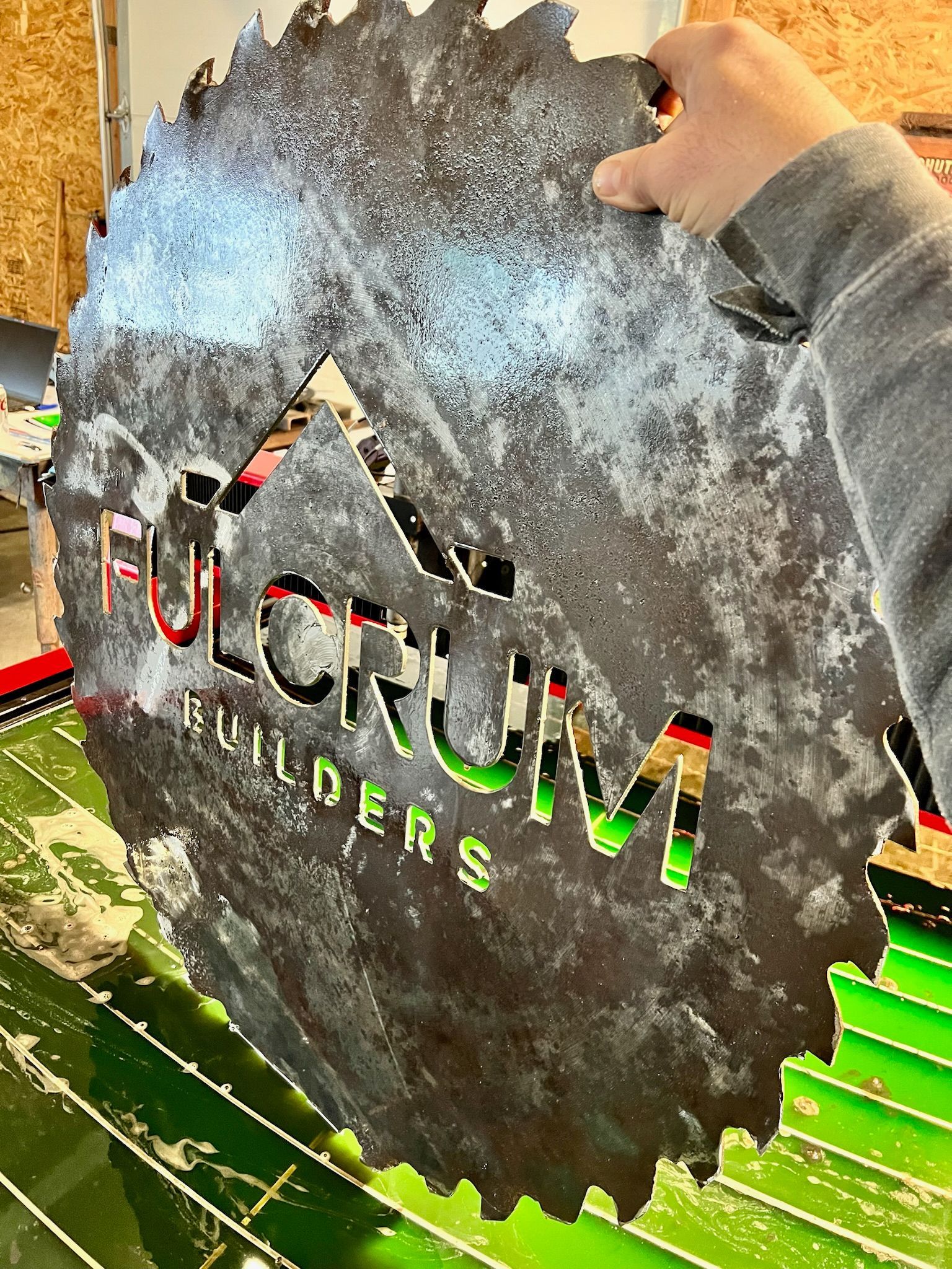A person is holding a circular saw blade with the word builders cut out of it.