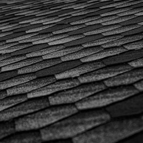 Close-up of asphalt roof shingles in varying shades of gray.