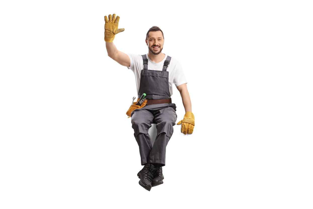 Construction worker in overalls and gloves waves, seated, smiling.