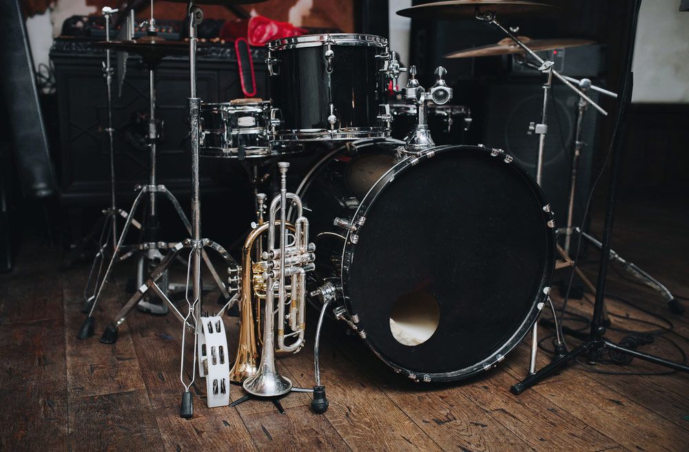 Black Drum Kit And A Microphone Stand Are On Stage — Kennedy Amplifier Hire Service In Mackay QLD