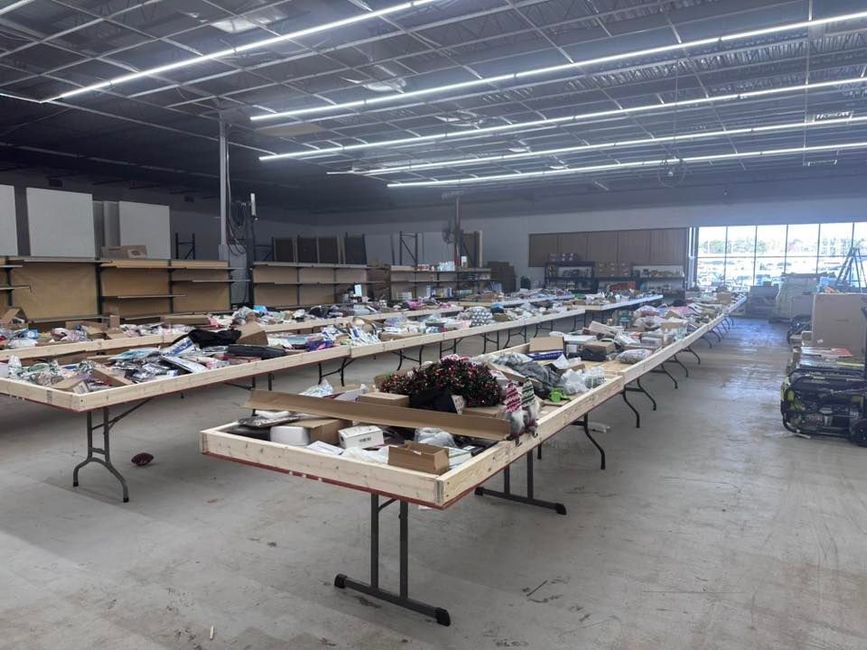 A large warehouse filled with lots of tables and boxes.