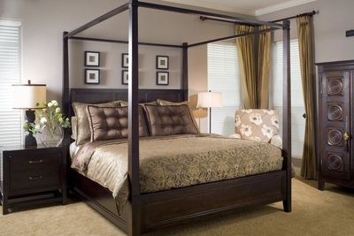 A bedroom with a canopy bed and a chair