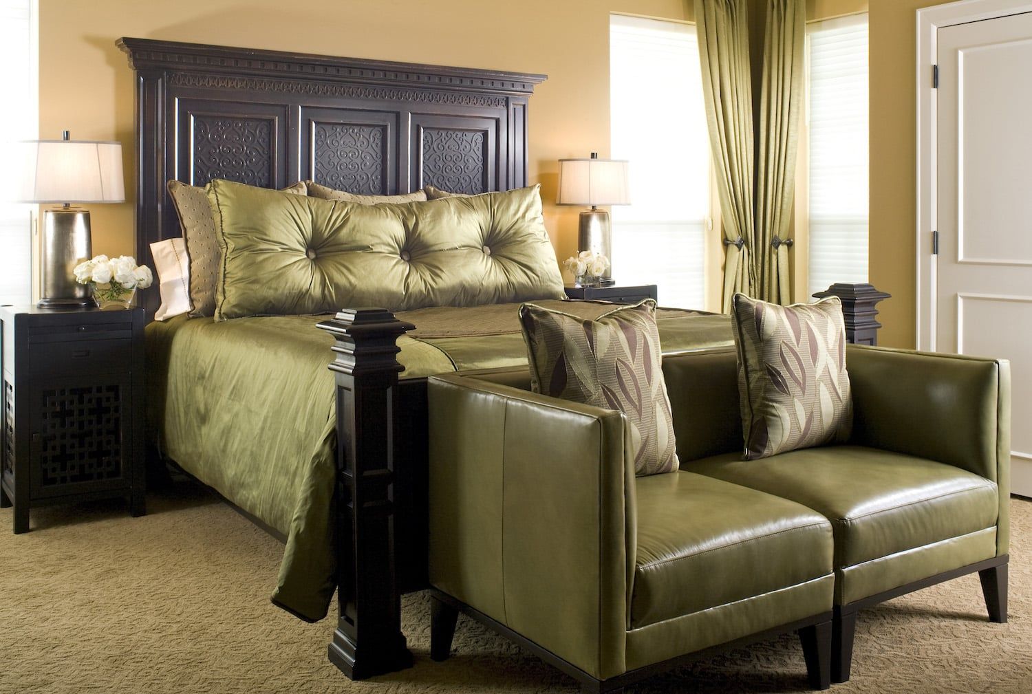 A bedroom with a king size bed and two chairs