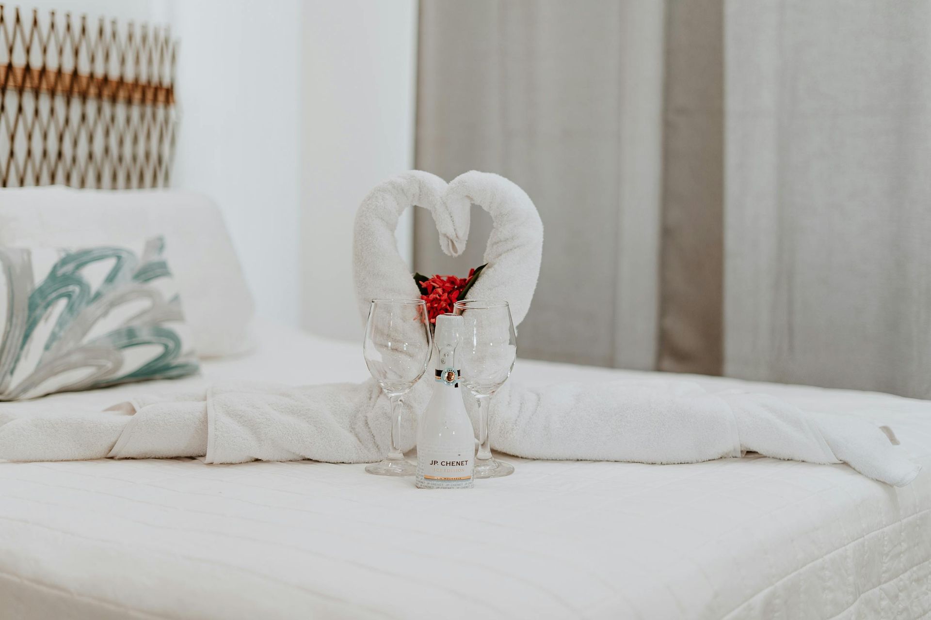 Hay un corazón hecho con toallas en la cama.