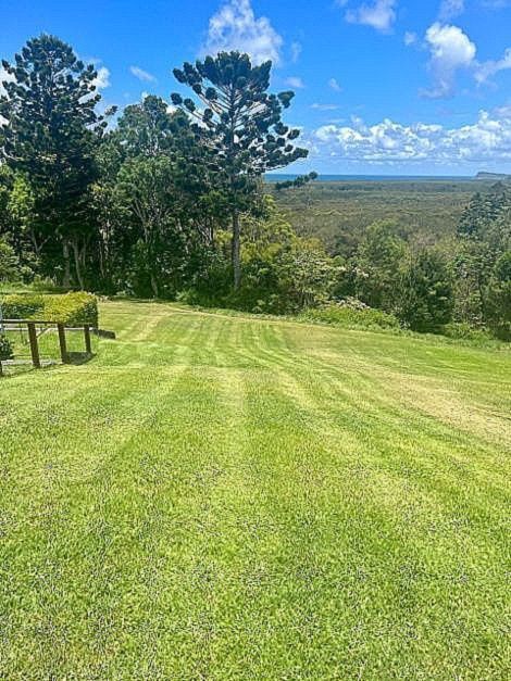 A Person Is Riding A Lawn Mower On A Lush Green Lawn — The Garden Folk In Suffolk Park, NSW