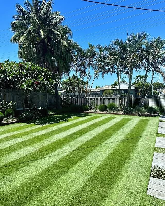 A Man Is Using A Lawn Mower To Cut The Grass In A Garden — The Garden Folk In Ballina, NSW