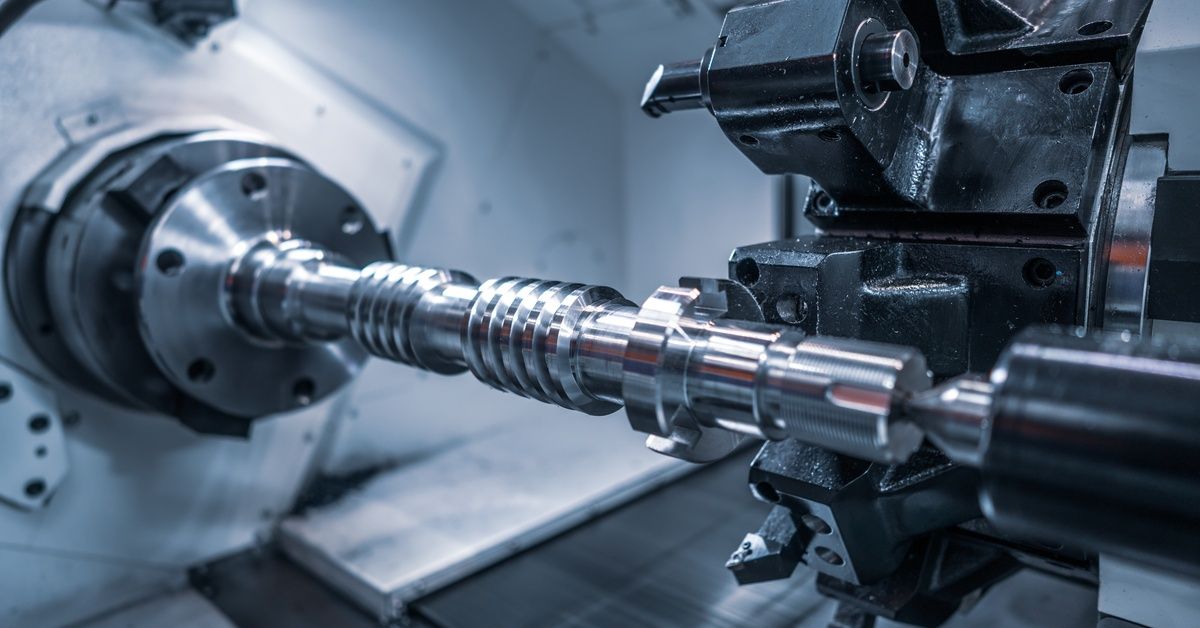 An interior view of a CNC lathe machine removing material from a spinning cylindrical piece of metal