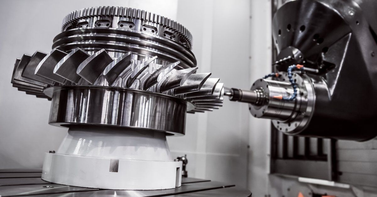 A CNC milling machine uses a cutting tool on a horizontal axis to craft a complex metal piece with gears.