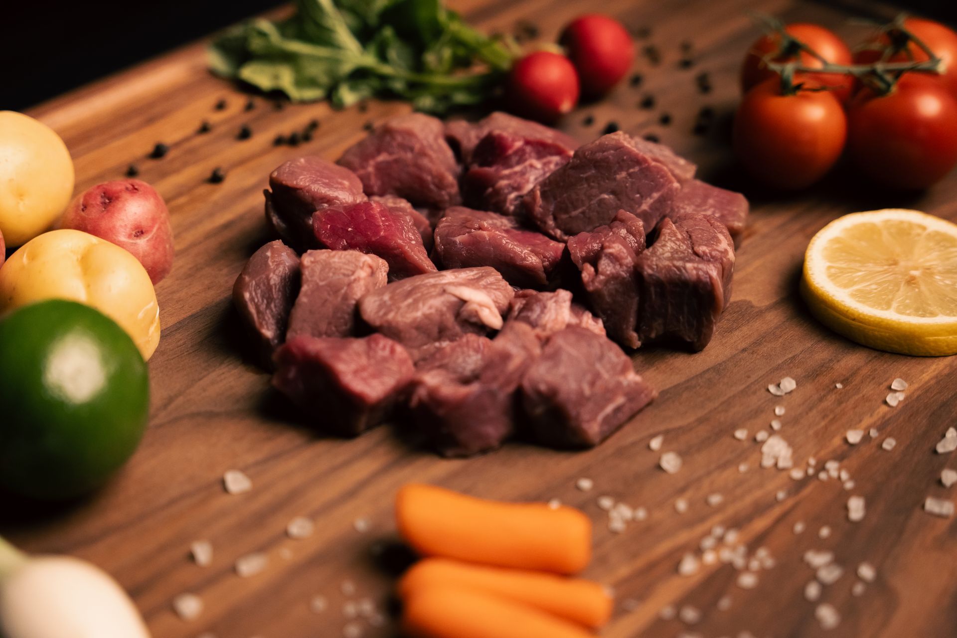 A wooden table topped with meat , vegetables and rancho el mirador logo
