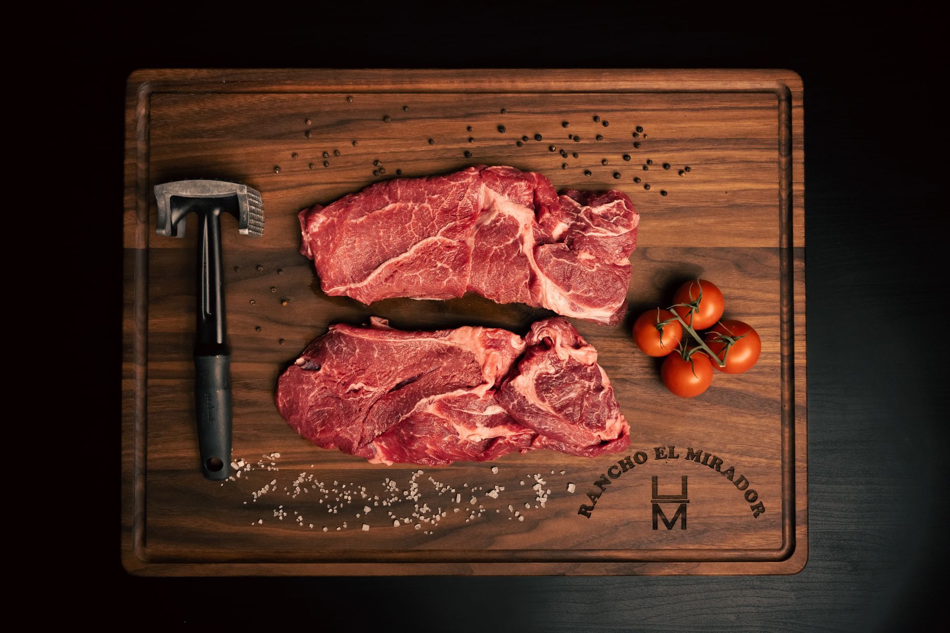 A piece of raw steak is sitting on a wooden cutting board.