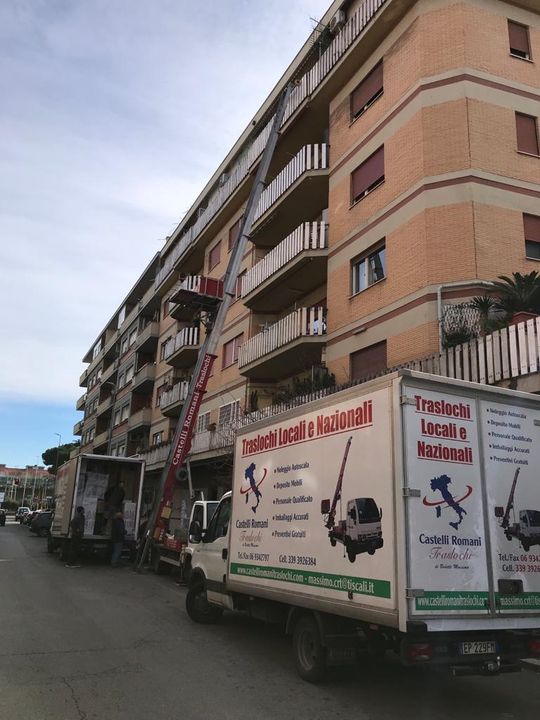 Un camion bianco è parcheggiato davanti a un alto edificio