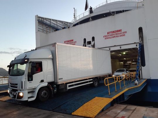 Un camion bianco è parcheggiato sulla rampa di un traghetto.