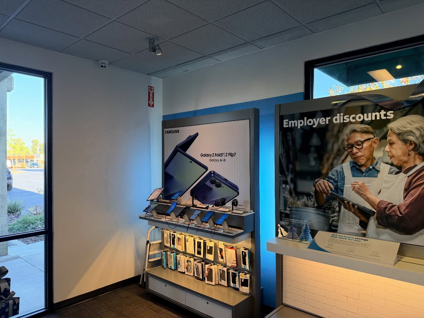 Interior of a cell phone store, display with phones and promotional materials.