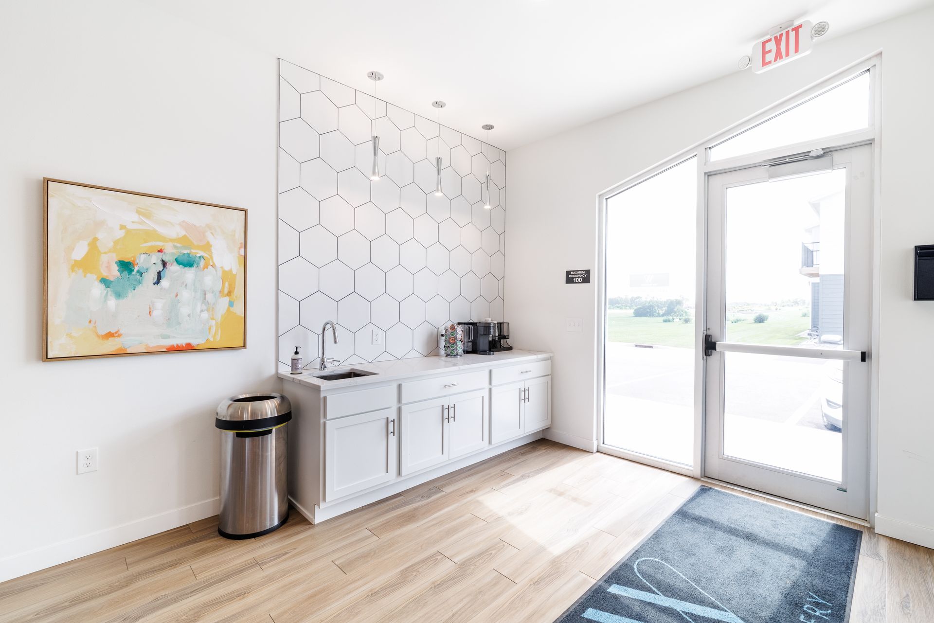 The entrance of the clubhouse with a sink and cabinets.