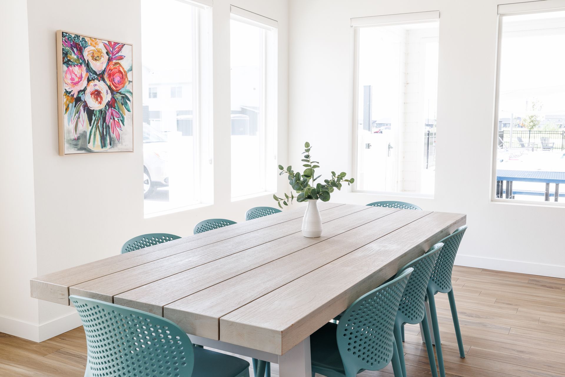 A table and chairs in the clubhouse with a vase.