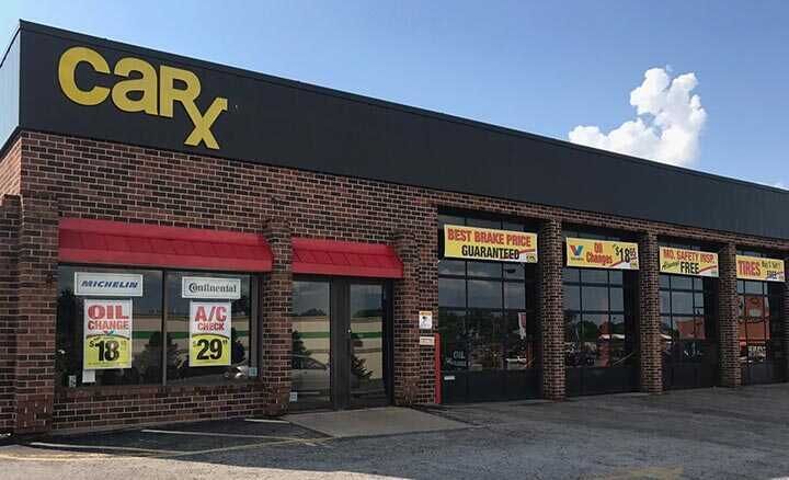CarX auto repair shop with brick exterior and black roof. Offers oil changes and A/C service.