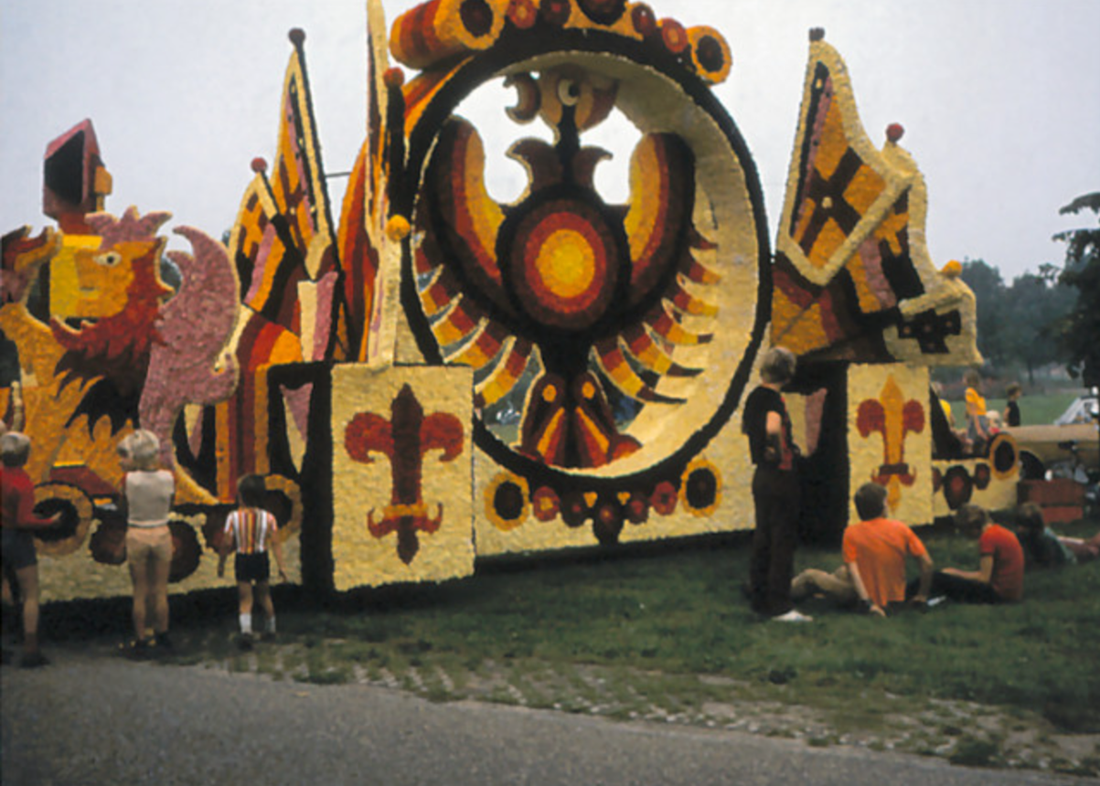 Een kleurrijke praalwagen met een leeuw en een kruis erop