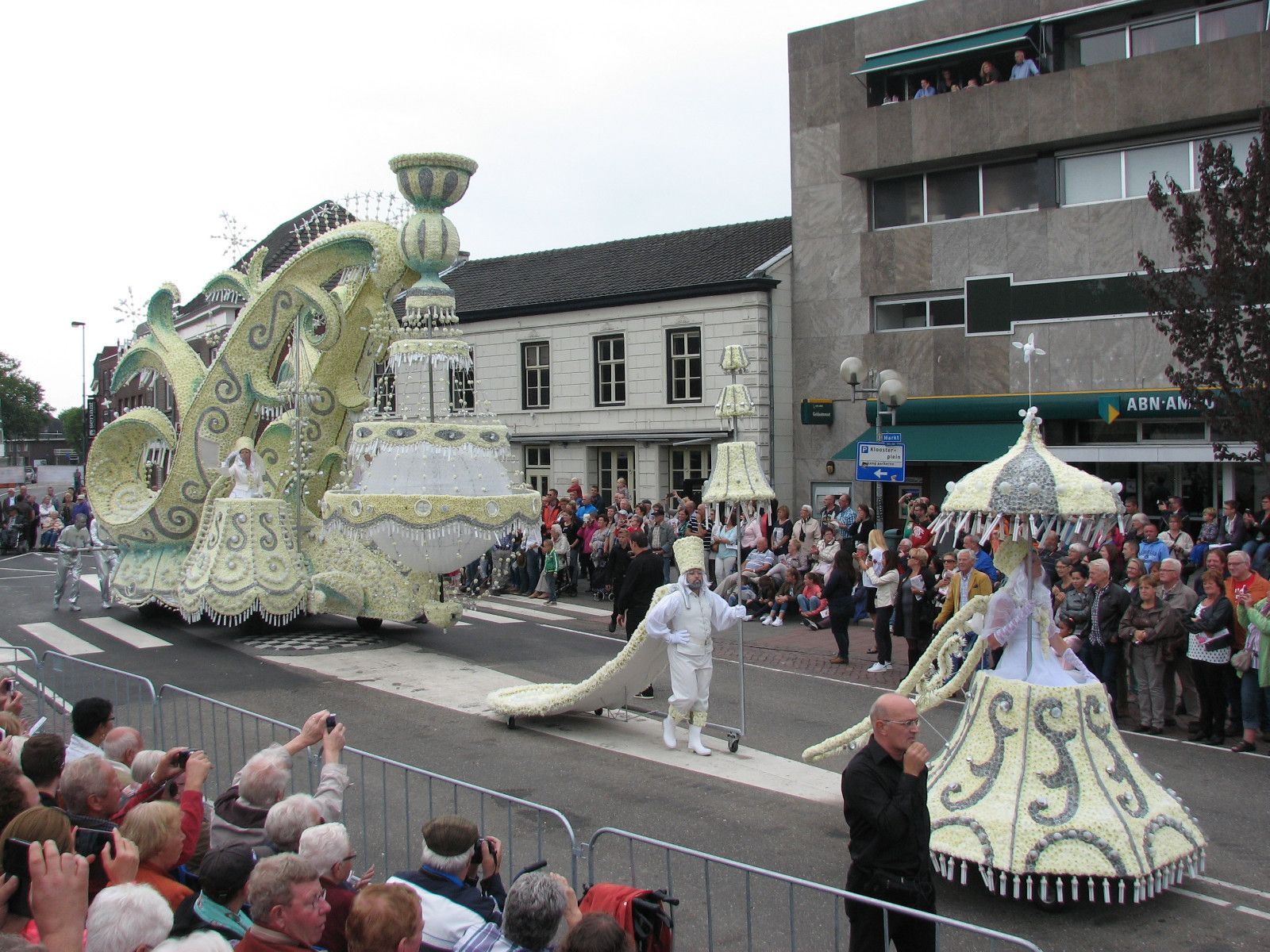 Een menigte mensen die een parade met een grote praalwagen bekijkt