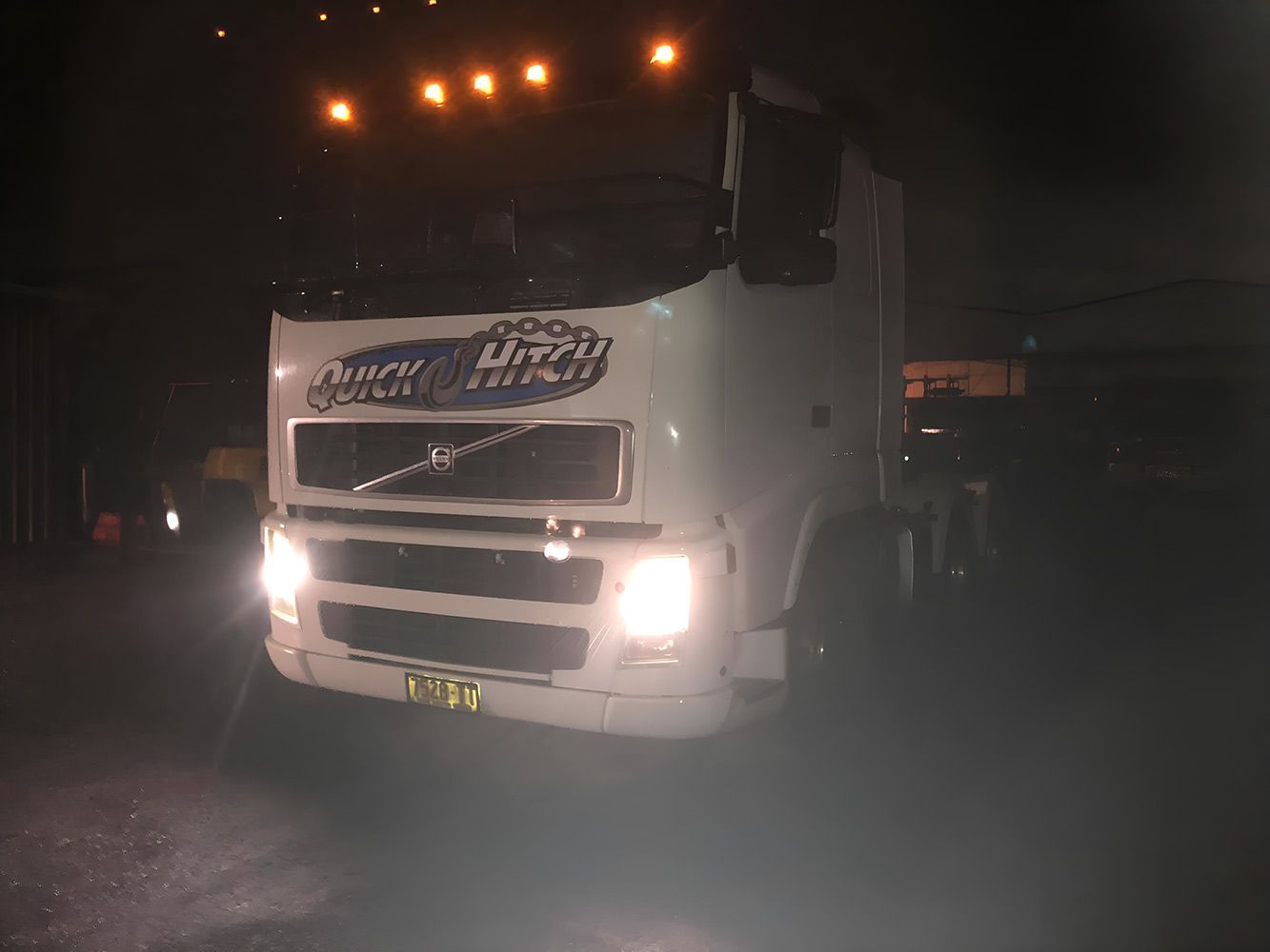 A White Truck is Parked in a Dark Parking Lot at Night — Quick Hitch Towing & Tilt Tray Services Illawarra in Oak Flats, NSW