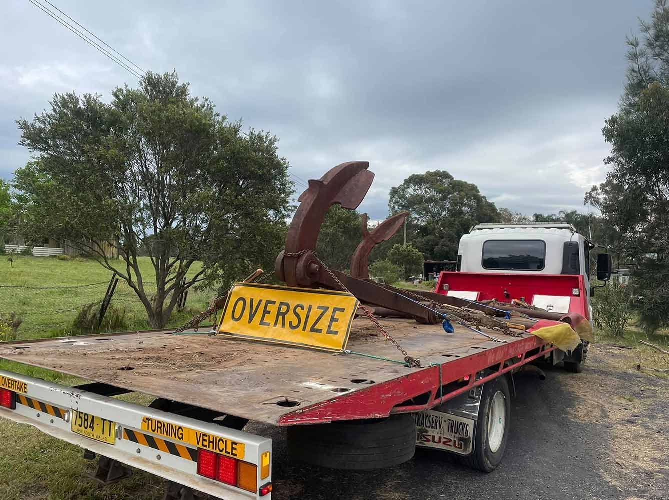 A Red Tow Truck is Parked on the Side of the Road — Quick Hitch Towing & Tilt Tray Services Illawarra in Oak Flats, NSW