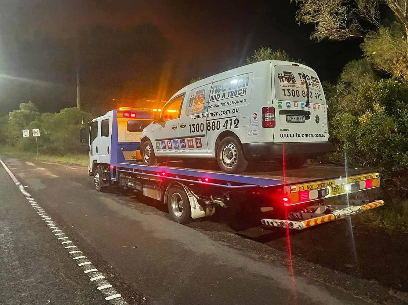 A Tow Truck is Towing a Van Down the Road at Night — Quick Hitch Towing & Tilt Tray Services Illawarra in Helensburgh, NSW