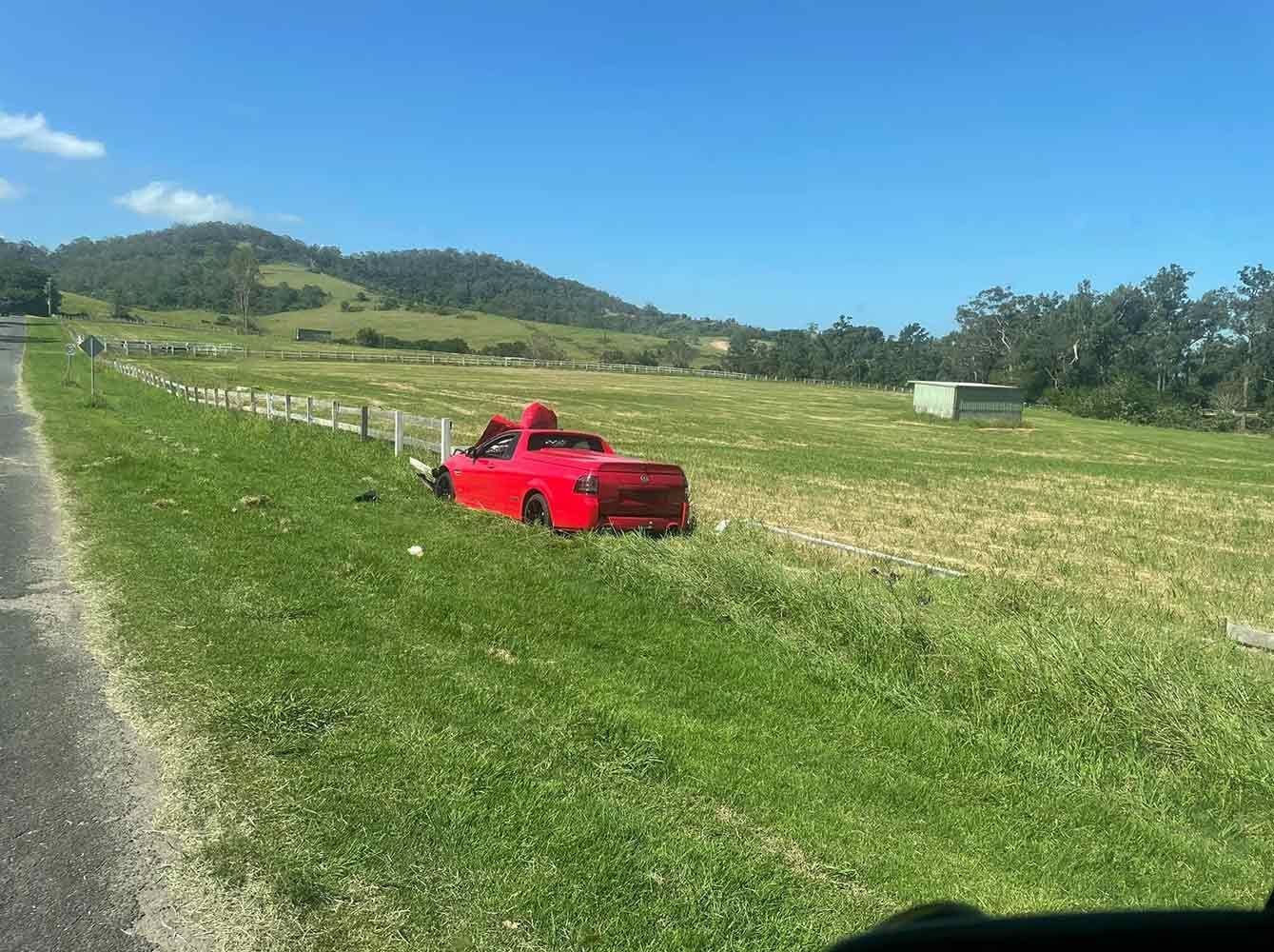 A Red Truck is Sitting in the Grass on the Side of the Road — Quick Hitch Towing & Tilt Tray Services Illawarra in Dapto, NSW