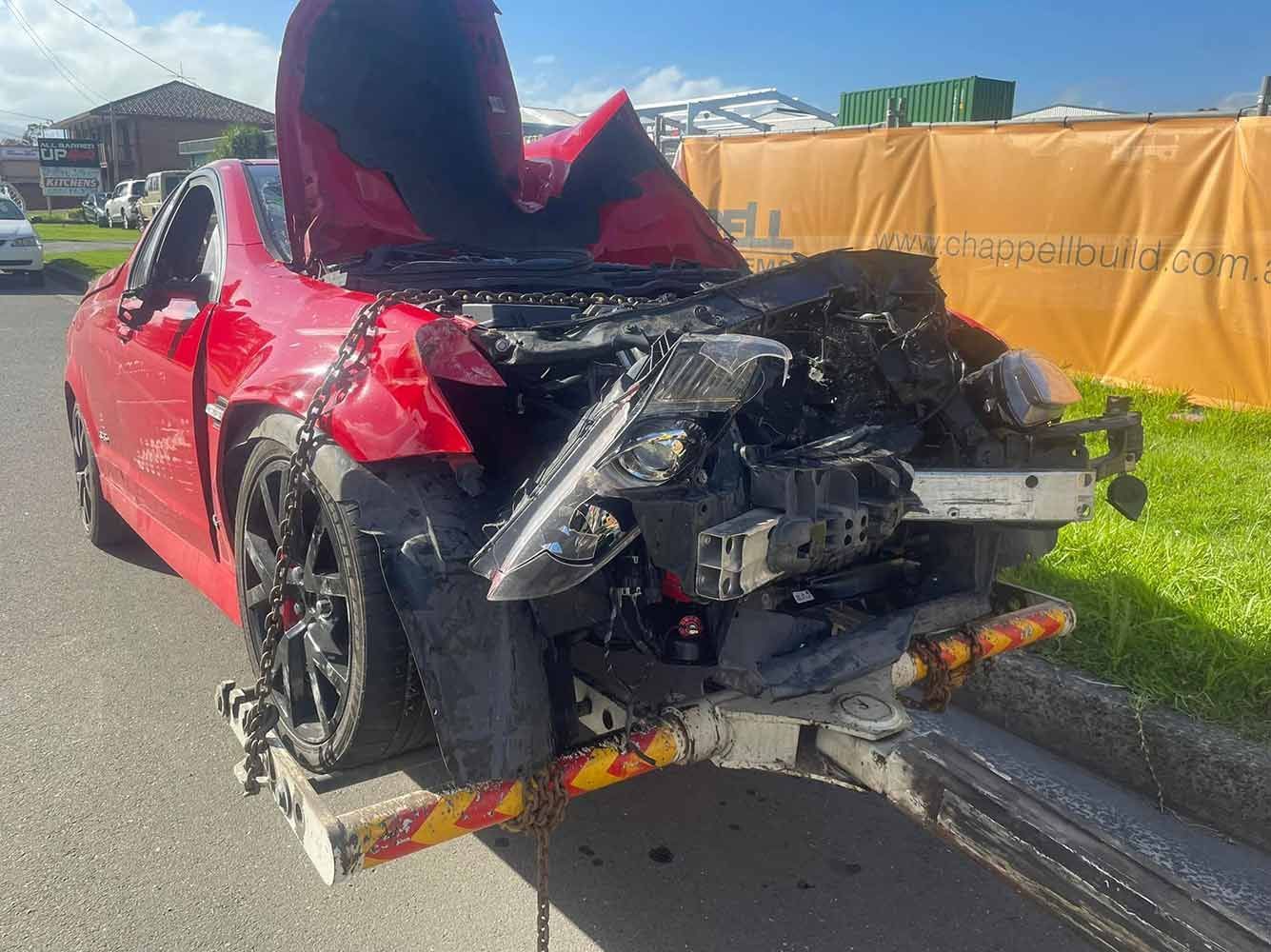 A Red Car is Sitting on Top of a Tow Truck — Quick Hitch Towing & Tilt Tray Services Illawarra in Shellharbour, NSW