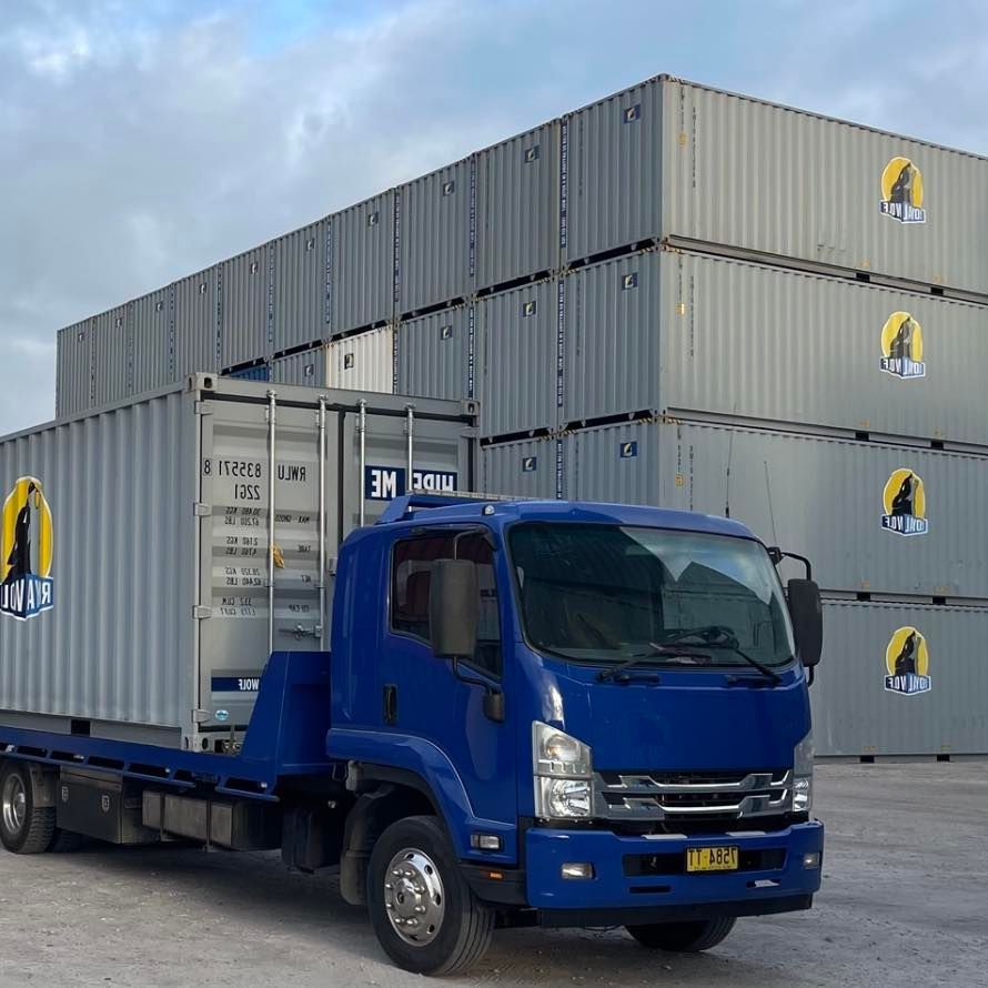 A Truck is Parked in Front of a Stack of Containers — Quick Hitch Towing & Tilt Tray Services Illawarra in Oak Flats, NSW