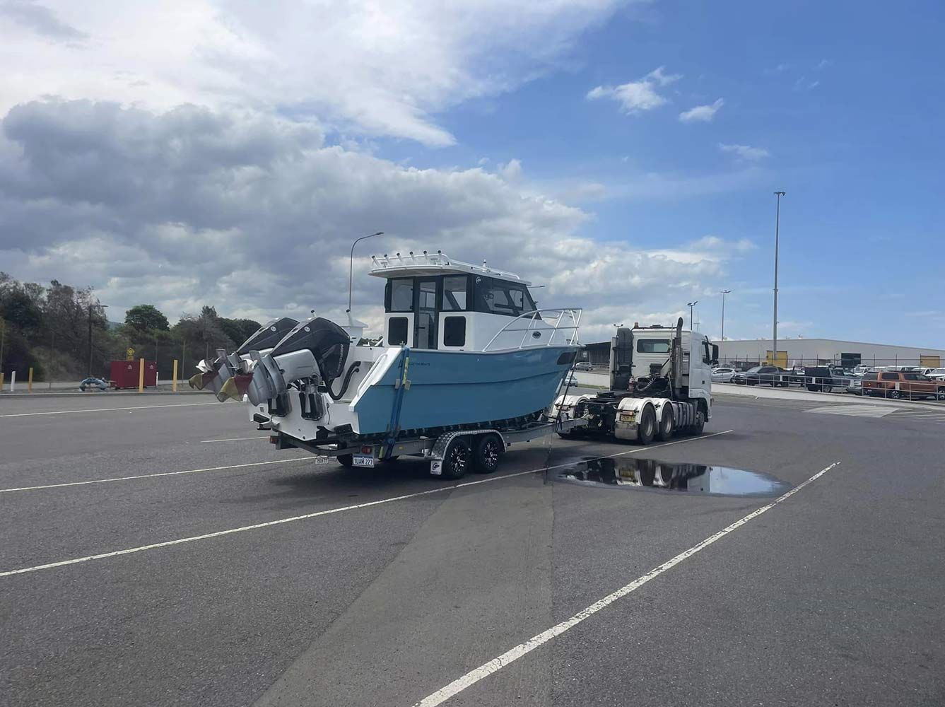 A Boat is Being Towed Down a Road by a Truck — Quick Hitch Towing & Tilt Tray Services Illawarra in Oak Flats, NSW