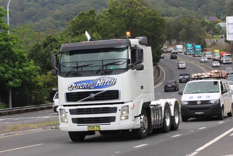 A White Truck is Driving Down a Highway — Quick Hitch Towing & Tilt Tray Services Illawarra in Oak Flats, NSW