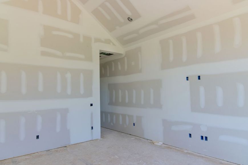 Interior room with unfinished drywall walls and ceiling, awaiting paint.