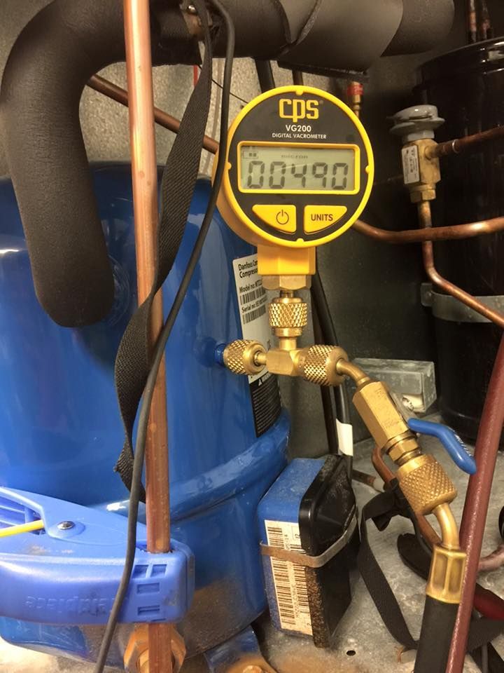 A digital gauge is sitting next to a blue compressor.