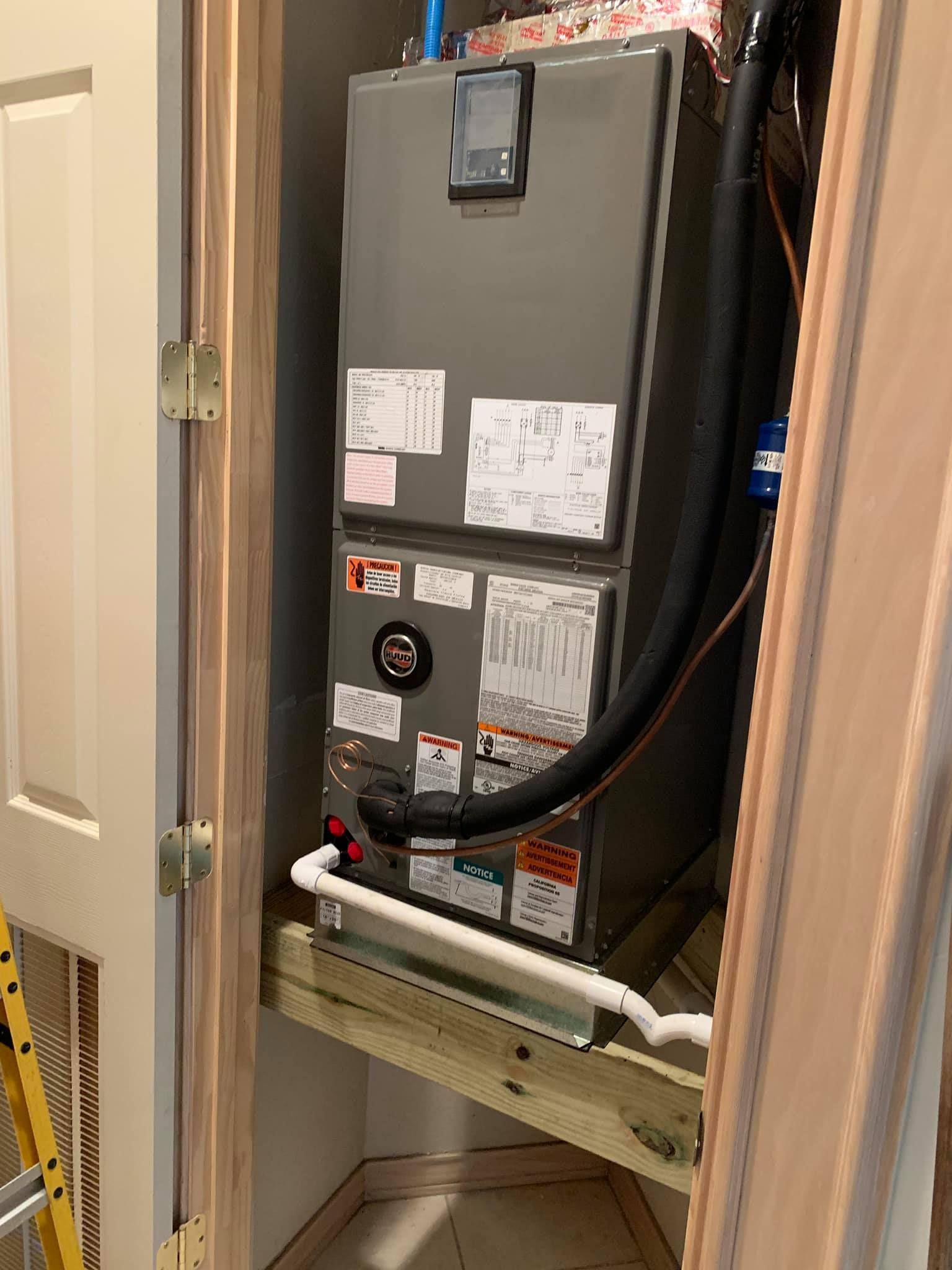 An air conditioner is sitting inside of a closet.