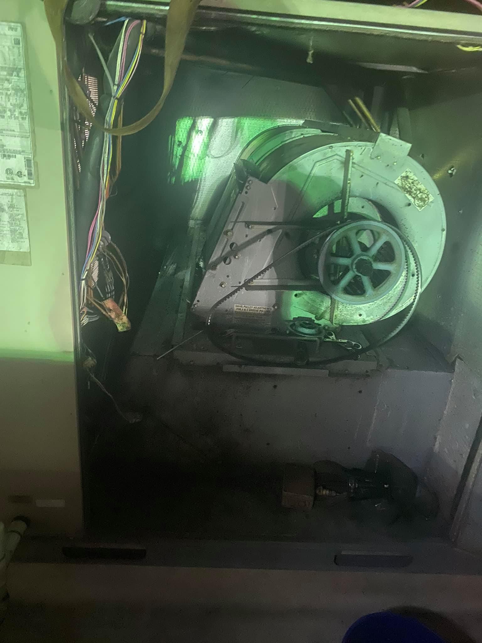 A close up of a fan in a room with a green light shining on it.