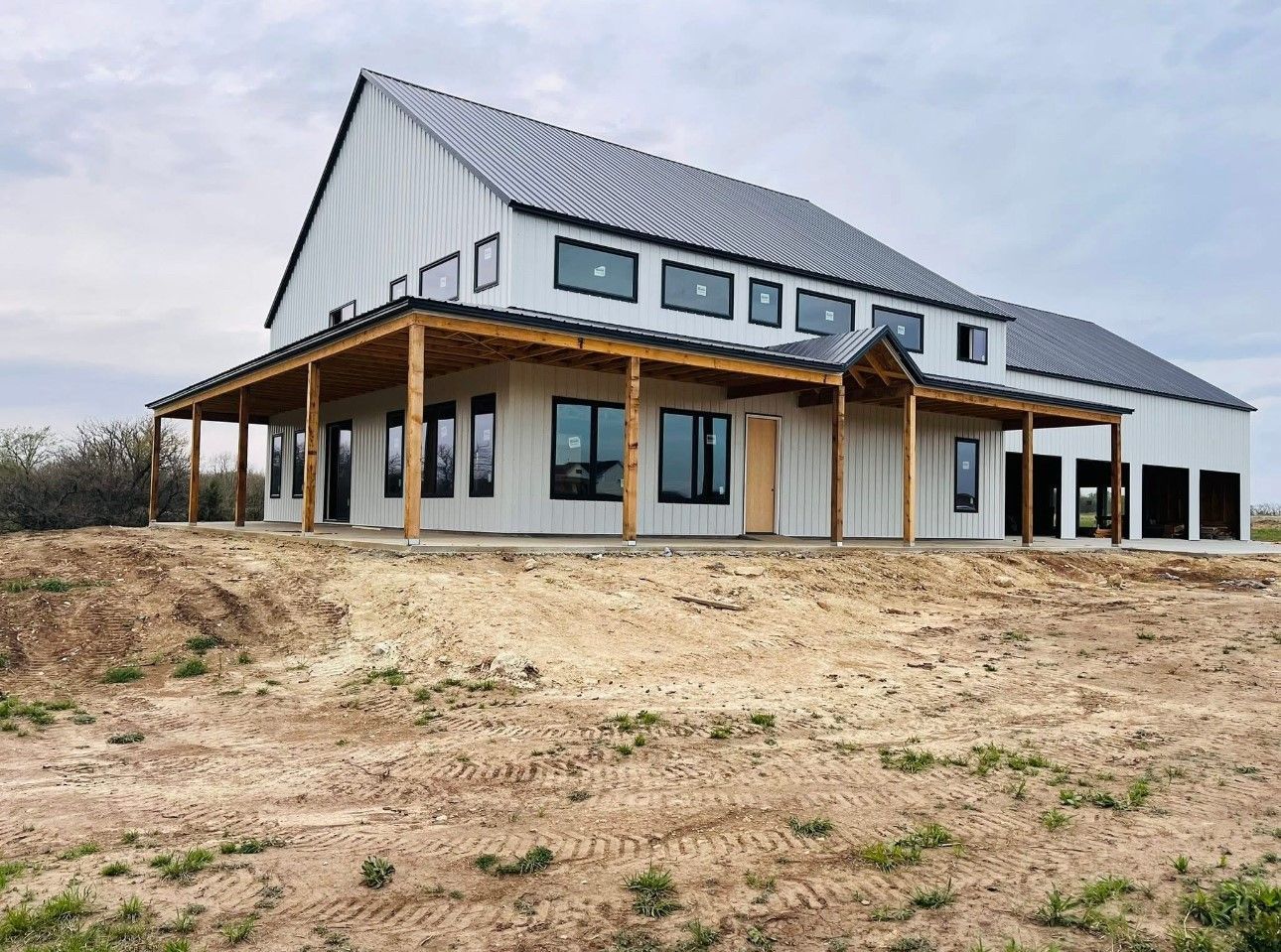 A brick house with a garage and a shed in front of it.