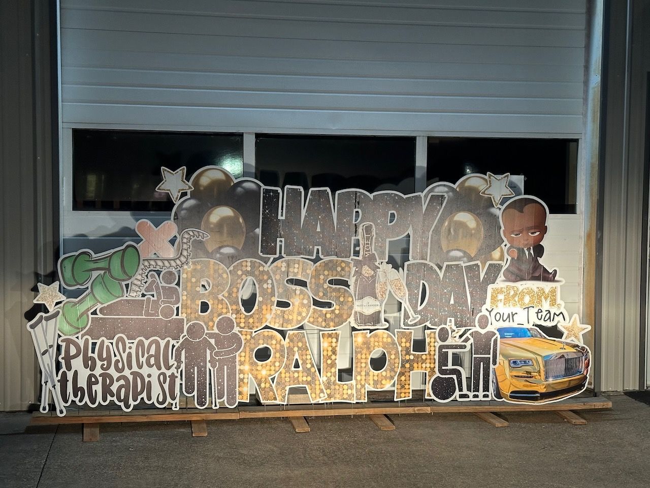 A large sign that says `` happy boss sunday '' is sitting in front of a garage door.